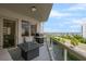 Balcony featuring a grill, fire table, seating, and views of the beach and palm trees at 128 Golden Gate Pt # 501B, Sarasota, FL 34236