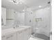 Sleek bathroom featuring dual vanity, white marble countertops, mosaic tile, and a glass-enclosed walk-in shower at 128 Golden Gate Pt # 501B, Sarasota, FL 34236