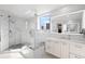 Bright bathroom with glass shower, vanity, and luxurious marble tiling at 128 Golden Gate Pt # 501B, Sarasota, FL 34236