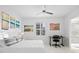 Bright bedroom with white bedding, beach art, a study desk, and window with city view and plantation shutters at 128 Golden Gate Pt # 501B, Sarasota, FL 34236