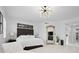 Spacious main bedroom featuring a white bed, modern lighting fixture, and decorative floor mirror at 128 Golden Gate Pt # 501B, Sarasota, FL 34236