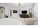 Expansive main bedroom featuring white furniture, dark wood dresser, large flatscreen tv, and modern decorative mirror at 128 Golden Gate Pt # 501B, Sarasota, FL 34236