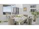 Well-lit dining room with marble table, velvet chairs, decorative art and lush plant life at 128 Golden Gate Pt # 501B, Sarasota, FL 34236