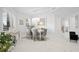 Elegant dining area with marble floors, stylish gray chairs, and bright natural light at 128 Golden Gate Pt # 501B, Sarasota, FL 34236