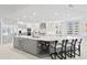 Spacious white kitchen with island bar seating, stainless steel appliances, and a built-in wine refrigerator at 128 Golden Gate Pt # 501B, Sarasota, FL 34236