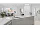 Contemporary kitchen featuring a gray island with a stainless steel sink, quartz countertops and access to dining area at 128 Golden Gate Pt # 501B, Sarasota, FL 34236