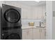 Modern laundry room featuring LG washer/dryer, white cabinets, quartz countertop, undermount sink, and stylish backsplash at 128 Golden Gate Pt # 501B, Sarasota, FL 34236
