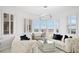 Bright living room with comfortable sofas and bay window with plantation shutters and water view at 128 Golden Gate Pt # 501B, Sarasota, FL 34236