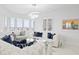 Bright living room featuring white tufted sofas, stylish decor, bay windows, and water views at 128 Golden Gate Pt # 501B, Sarasota, FL 34236