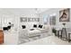 Bright living room with an L-shaped couch, ottoman, modern art, and tile floors at 128 Golden Gate Pt # 501B, Sarasota, FL 34236