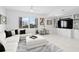 Bright living room with sectional sofa, white marble floors, and a stunning city view through plantation shutters at 128 Golden Gate Pt # 501B, Sarasota, FL 34236