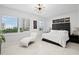 Bright main bedroom with tile floors, modern lighting, chaise lounge, and stunning views at 128 Golden Gate Pt # 501B, Sarasota, FL 34236