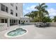 Community pool and jacuzzi surrounded by palm trees and outdoor dining area at 128 Golden Gate Pt # 501B, Sarasota, FL 34236