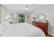 Bright bedroom features hardwood floors, balcony access, and comfortable furnishings at 13331 Drysdale Ave, Port Charlotte, FL 33981