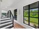 A bright hallway featuring modern black trim windows with a lush green view at 13331 Drysdale Ave, Port Charlotte, FL 33981