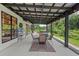 Relaxing covered patio with outdoor seating, adjacent hot tub, and views of mature landscaping at 13331 Drysdale Ave, Port Charlotte, FL 33981