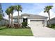 One-story house with gray garage door and palm trees at 14573 Ponce De Leon Trl, Port Charlotte, FL 33981