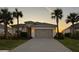 Two-story house with a gray garage door and palm trees in the front yard at 14573 Ponce De Leon Trl, Port Charlotte, FL 33981