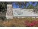 Attractive stone and stucco community sign with lush landscaping and clear blue sky at 16916 Rosedown Gln, Parrish, FL 34219