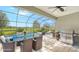 Relaxing screened outdoor patio area featuring comfortable seating, dining table, grill, and serene backyard view at 16916 Rosedown Gln, Parrish, FL 34219