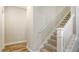 View of the carpeted staircase with white banister, leading to the upper floors of the home at 16916 Rosedown Gln, Parrish, FL 34219