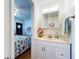 Bathroom vanity with decorative mirror, lighting, and fresh flowers viewed from bedroom at 3333 26Th E Ave # 1230, Bradenton, FL 34208