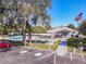 Exterior view of the community center with a pool, shuffleboard, parking area, and an American flag at 3333 26Th E Ave # 1230, Bradenton, FL 34208