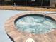 Close up of a bubbling hot tub with a tiled border and a metal handrail at 3333 26Th E Ave # 1230, Bradenton, FL 34208