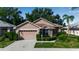 Tan one-story house with two car garage and landscaping at 519 Catalina Isles Cir, Venice, FL 34292