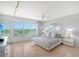 Main bedroom with water views, light wood floors, and a ceiling fan at 603 Longboat Club Rd # 602N, Longboat Key, FL 34228