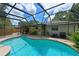 Enclosed pool area with a waterfall, patio furniture and lush landscaping at 6933 9Th E Ct, Sarasota, FL 34243