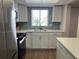 Modern kitchen with white cabinets, stainless steel appliances, and light blue tile backsplash at 3600 Lake Bayshore Drive Bld. K # 221, Bradenton, FL 34205