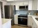 Modern kitchen with white cabinets, stainless steel appliances, and light blue tile backsplash at 3600 Lake Bayshore Drive Bld. K # 221, Bradenton, FL 34205