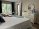 Bright bedroom with a dresser and access to a balcony at 3600 Lake Bayshore Drive Bld. K # 221, Bradenton, FL 34205