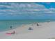 Expansive beach scene with people relaxing along the shoreline with clear skies, highlighting a relaxing coastal lifestyle at 4995 Pepperwood Pl, Venice, FL 34293
