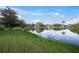 Serene lakefront view with lush green grass at 3556 E Forest Lake Dr, Sarasota, FL 34232