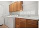 Laundry room with washer, dryer, and wood cabinets at 13180 Ipolita St, Venice, FL 34293