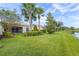 Landscaped backyard oasis with lush lawn and water view at 13180 Ipolita St, Venice, FL 34293