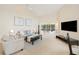 Living room with ample natural light, neutral decor, and patio access at 4995 Pepperwood Pl, Venice, FL 34293