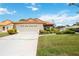 Front view of house showcasing a two-car garage and landscaping at 4995 Pepperwood Pl, Venice, FL 34293