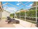 Relaxing screened patio with lounge chairs, perfect for outdoor enjoyment at 4995 Pepperwood Pl, Venice, FL 34293