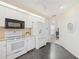White kitchen features stainless steel appliances and dark flooring at 4995 Pepperwood Pl, Venice, FL 34293