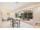 Sunroom with access to a screened patio, lounge chairs, and small table at 4995 Pepperwood Pl, Venice, FL 34293