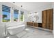 Spa-like bathroom with a soaking tub, double vanity, and marble floors at 45 Bunker Ln, Rotonda West, FL 33947