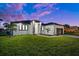 Modern, single-story home with a two-car garage and lush lawn at 45 Bunker Ln, Rotonda West, FL 33947