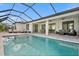 Large pool with covered patio, lounge chairs, and canal views at 45 Bunker Ln, Rotonda West, FL 33947