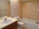 Bathroom with vanity, toilet and tub-shower combination with peach tile surround at 4973 Village Gardens Dr # 50, Sarasota, FL 34234