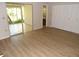 Bright bedroom with wood-look floors, access to a sunroom, and a spacious closet at 4973 Village Gardens Dr # 50, Sarasota, FL 34234