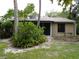 Exterior view of the house with greenery and a screened in patio at 4973 Village Gardens Dr # 50, Sarasota, FL 34234