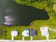 Three houses near a lake with green lawns and swimming pools at 1094 Rotonda Cir, Rotonda West, FL 33947